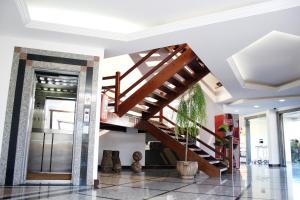 una escalera de madera en una habitación con vestíbulo en Hotel Caiçara Bistrô e Eventos Ltda, en Itaperuna
