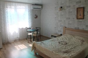 een slaapkamer met een bed, een tafel en een raam bij Studio on main street in Bălţi