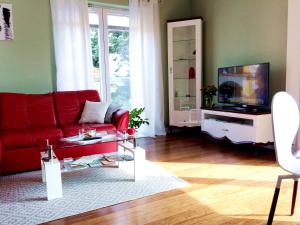 salon z czerwoną kanapą i telewizorem w obiekcie NEPTUN 46 - 2 sypialnie w Olsztynie