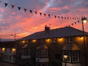 a building with a string of flags in front of a sunset at Tyacks Hotel in Camborne