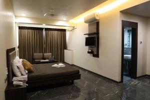 Habitación de hotel con cama y sofá en Hotel Jawahar en Ulhāsnagar