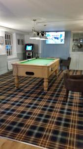 a room with a pool table on a rug at Tyacks Hotel in Camborne
