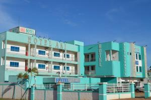 um hotel na praia com um edifício azul em Aki Hotel em Cáceres