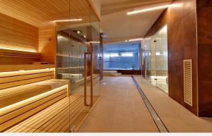 a sauna with glass walls and a walk in shower at Hotel Elite in Caorle