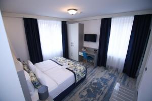 una camera d'albergo con un letto, una scrivania e una finestra di Old Town Hotel a Sarajevo