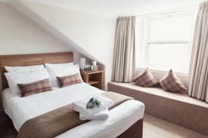 1 dormitorio con 2 camas con almohadas y ventana en Inverkip Hotel, en Inverkip