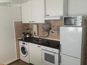 a kitchen with a white refrigerator and a washing machine at A&H Apartment in Oberhausen
