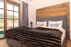 a bedroom with a large bed with a large window at Das Chalet in Schladming