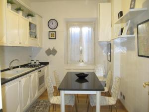a kitchen with a table and chairs and a clock on the wall at Casa Vacanze Pietro al Vaticano in Rome