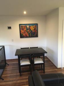een tafel en stoelen in een kamer met een schilderij aan de muur bij Pasaje Claro in Neuquén