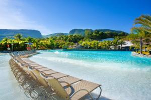 una fila de sillas en una playa de agua azul en Rio Quente Cristal Resorts in 