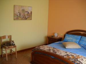 SovramonteにあるB&B L'Isola delle Roseのベッドルーム1室(ベッド1台、椅子、絵画付)
