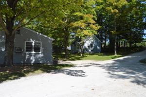 a house on the side of a road with trees at Baileys Sunset Cottages in Baileys Harbor