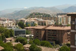 una ciudad con edificios y montañas en el fondo en Apartamento Góngora, en Granada