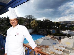 uno chef in piedi sul balcone di un resort di Pousada do Garimpo a Diamantina