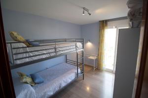 two bunk beds in a room with a window at Apartamento Góngora in Granada