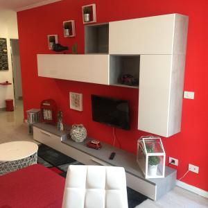 sala de estar con pared roja y TV en Apartamento Centro Frente Muralla, en Lugo