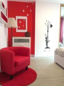 Sala de estar roja con silla roja y pared roja en Apartamento Centro Frente Muralla, en Lugo