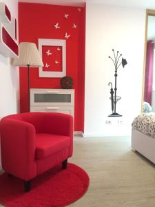 Sala de estar roja con silla roja y pared roja en Apartamento Centro Frente Muralla, en Lugo