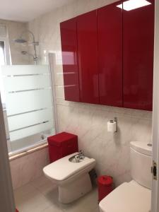 y baño con lavabo y armarios rojos. en Apartamento Centro Frente Muralla, en Lugo