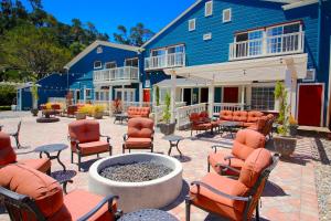 een patio met stoelen en een vuurplaats voor een blauw gebouw bij The Rigdon House in Cambria