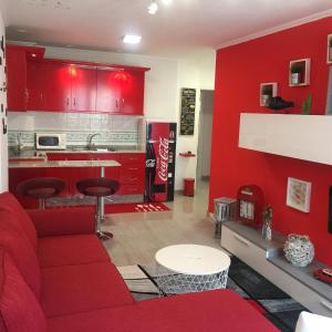 sala de estar roja con sofá rojo y cocina en Apartamento Centro Frente Muralla, en Lugo