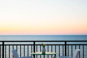 a table and chairs on a balcony overlooking the ocean at Mesogios Beach in Kissamos