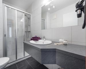 y baño blanco con lavabo y ducha. en Appartements Zahnleiten, en Untertauern