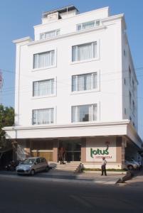ein weißes Gebäude mit einem Schild auf der Vorderseite in der Unterkunft Lotus Comfort - A Pondy Hotel in Puducherry
