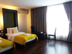 Postel nebo postele na pokoji v ubytování Nicha Suite Hua Hin Hotel