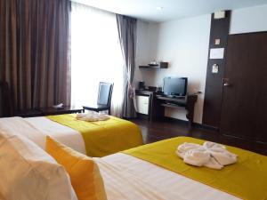 Postel nebo postele na pokoji v ubytování Nicha Suite Hua Hin Hotel