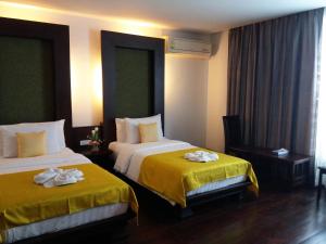 Postel nebo postele na pokoji v ubytování Nicha Suite Hua Hin Hotel