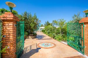a driveway with a green gate and a pathway at Casa Bianca Rais Gerbi in Finale