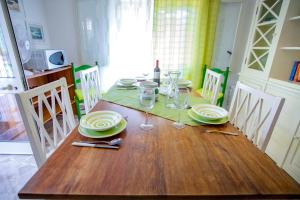 a wooden table with plates and wine glasses on it at Casa Bianca Rais Gerbi in Finale