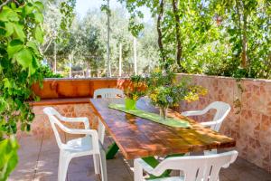 a wooden table and white chairs on a patio at Casa Bianca Rais Gerbi in Finale