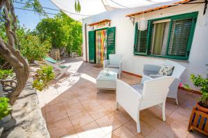 a patio with white chairs and a table at Casa Bianca Rais Gerbi in Finale