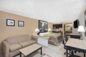 a hotel room with a bed and a living room at Super 8 by Wyndham McAllen-Downtown-Airport-LA Plaza Mall in McAllen