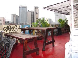 a wooden table and bench on top of a building at Oasis Guest House in Kuala Lumpur