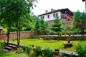 einen Garten mit einem Haus im Hintergrund in der Unterkunft Kalinia Guesthouse B&B in Kovachevitsa