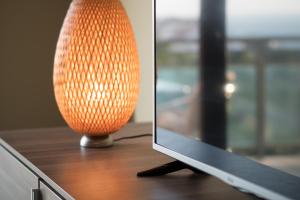 an orange lamp sitting on a table next to a computer monitor at Beach House Ericeira in Ericeira