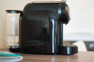 a coffee maker sitting on a table next to a glass at Beach House Ericeira in Ericeira