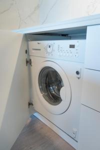 a washing machine in a kitchen under a counter at Beach House Ericeira in Ericeira