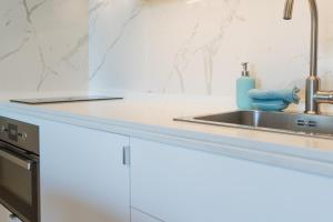 a kitchen counter with a sink and a sink at Beach House Ericeira in Ericeira