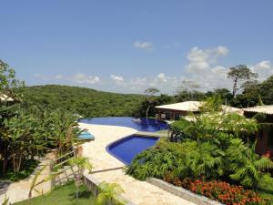 a resort with a swimming pool and a house at Villas do Pratagy Acerola in Maceió