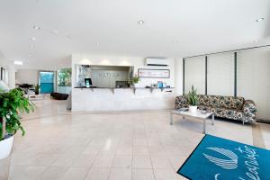 a lobby of a hotel with a couch and a counter at ULTIQA Shearwater Resort in Caloundra