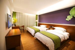 ein Hotelzimmer mit 2 Betten und einem Schreibtisch in der Unterkunft All Seasons Lodge in Zhangjiajie