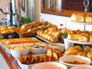 a buffet filled with different types of bread and pastries at Pousada dos Coqueiros Búzios in Búzios