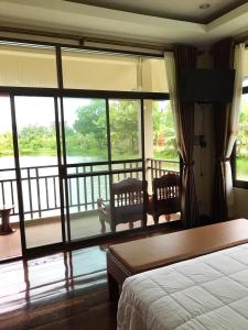 Schlafzimmer mit einem Bett und Blick auf einen Balkon in der Unterkunft Lantala Residence in Natai Beach