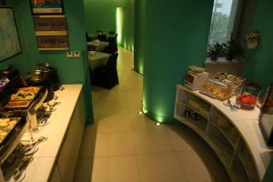 a kitchen with green walls and an oven with food at Jingjiang Inn Taiyuan Fuxi Street Wanda Plaza in Taiyuan