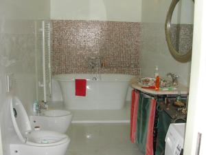 a bathroom with a tub and a toilet and a sink at Ilo Apartamentai in Vilnius